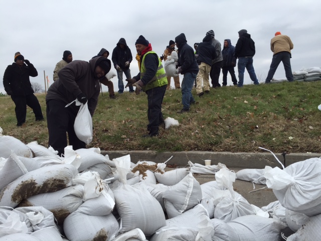 Volunteers load sand bags for the River Des Peres Levee